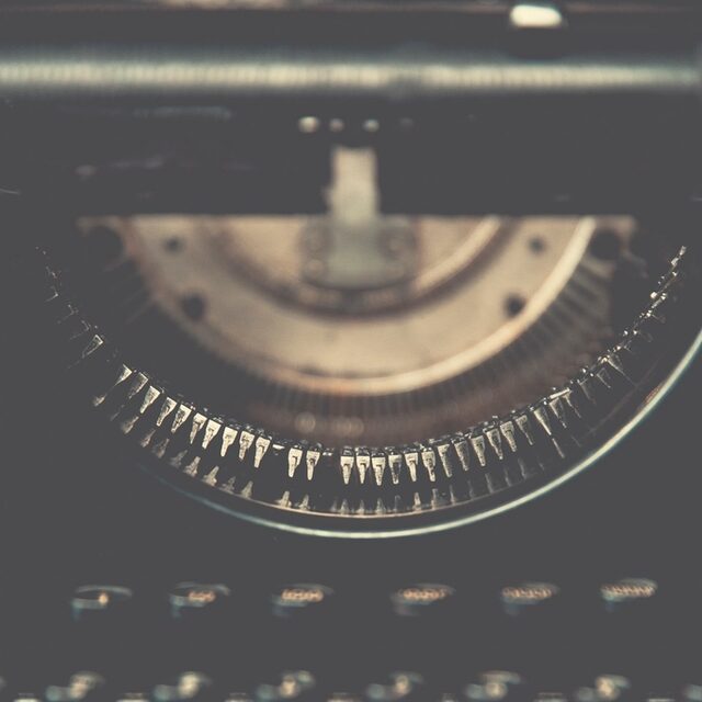 Macro photo of vintage typewriter type-bars, close in tone to picking out the one wrong character among many